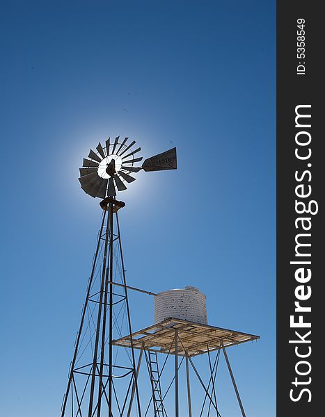 Rustic Windmill Against A Blue Sky