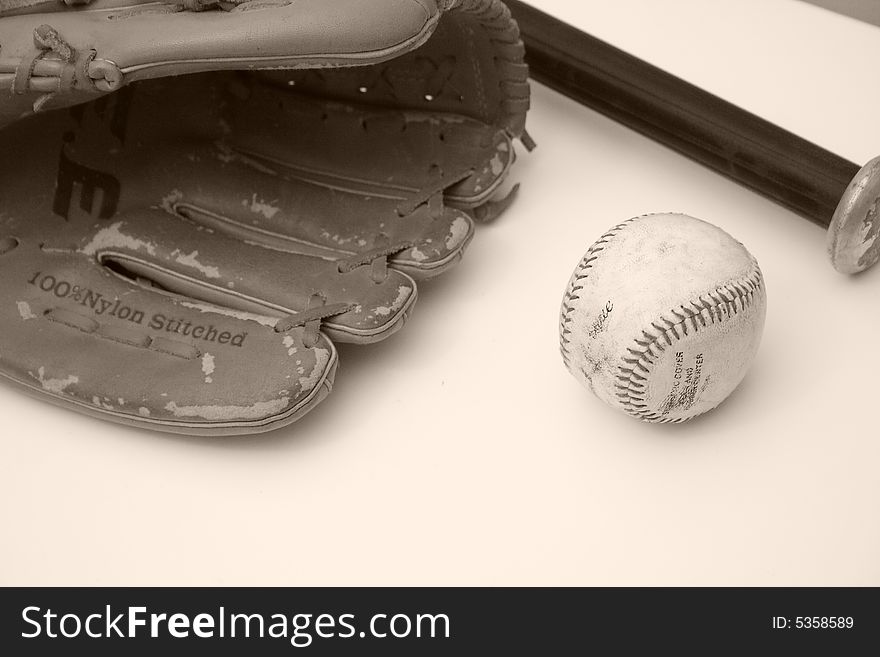 Close up of a vintage baseball and a baseball mitt and bat