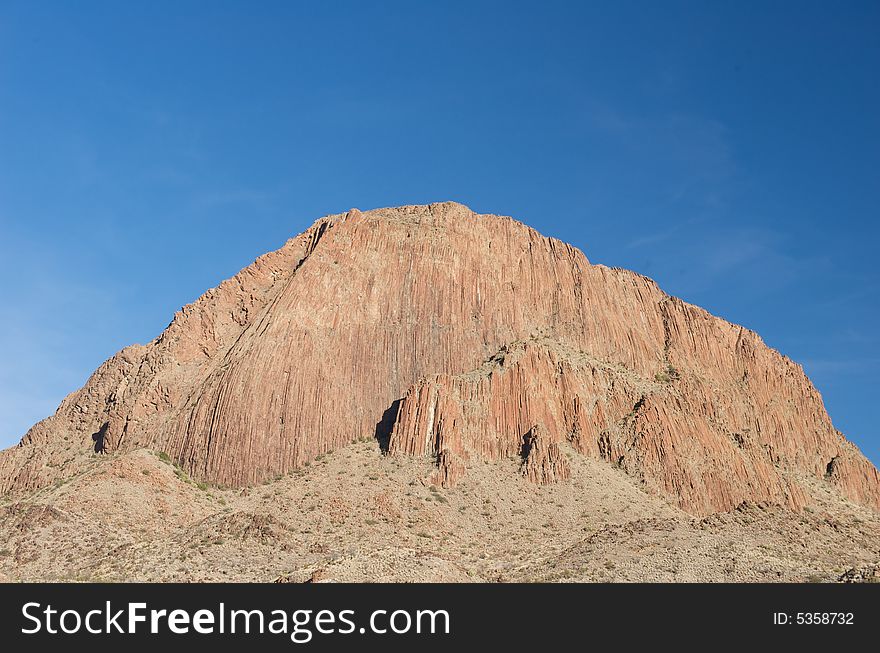 A large red mountain on a blue sky