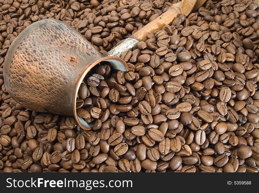 Turkish coffee pot on a background of coffee grains. Turkish coffee pot on a background of coffee grains.