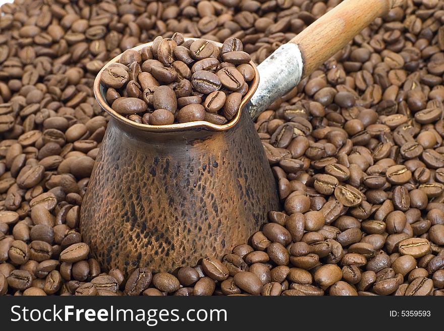Turkish coffee pot on a background of coffee grains. Turkish coffee pot on a background of coffee grains.
