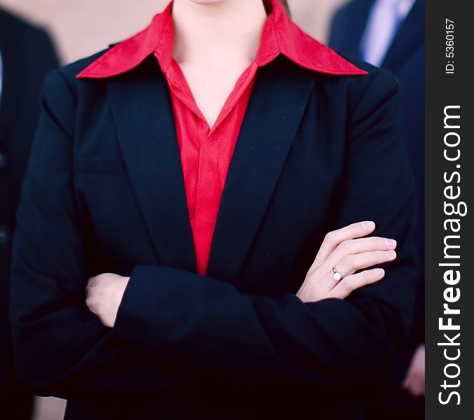 Businesswoman standing with two businessmen behind her