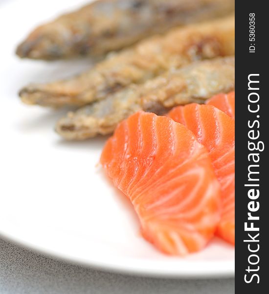 Salmon sashimi served with shishamo. Salmon sashimi served with shishamo