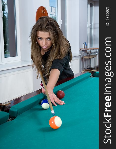 Young girl in short skirt playing snooker