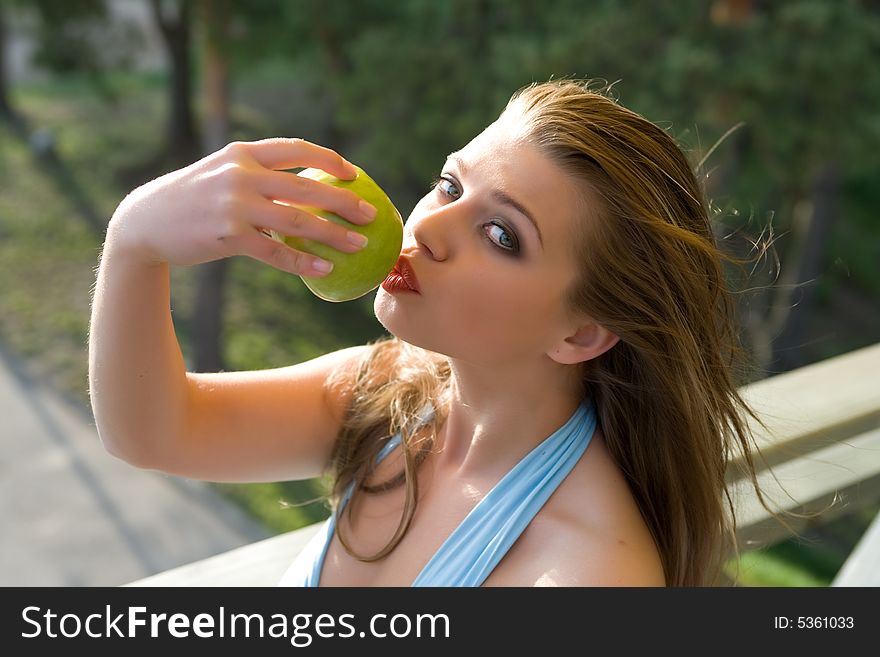 Girl with apple on sunset