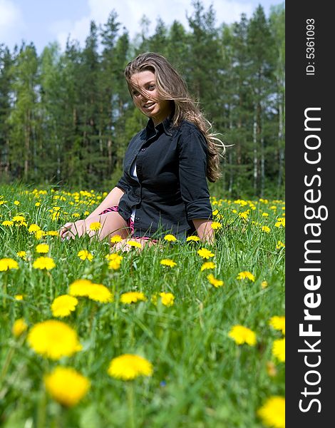Young girl in short skirt on dandelion field