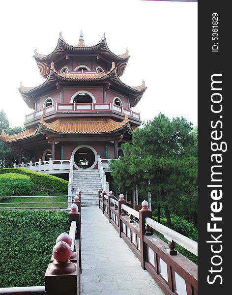 An ancient Chinese tower and the bridge leading toward it.