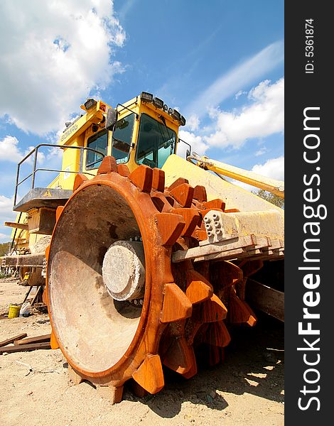 Heavy dump truck against blue sky operating in a sand