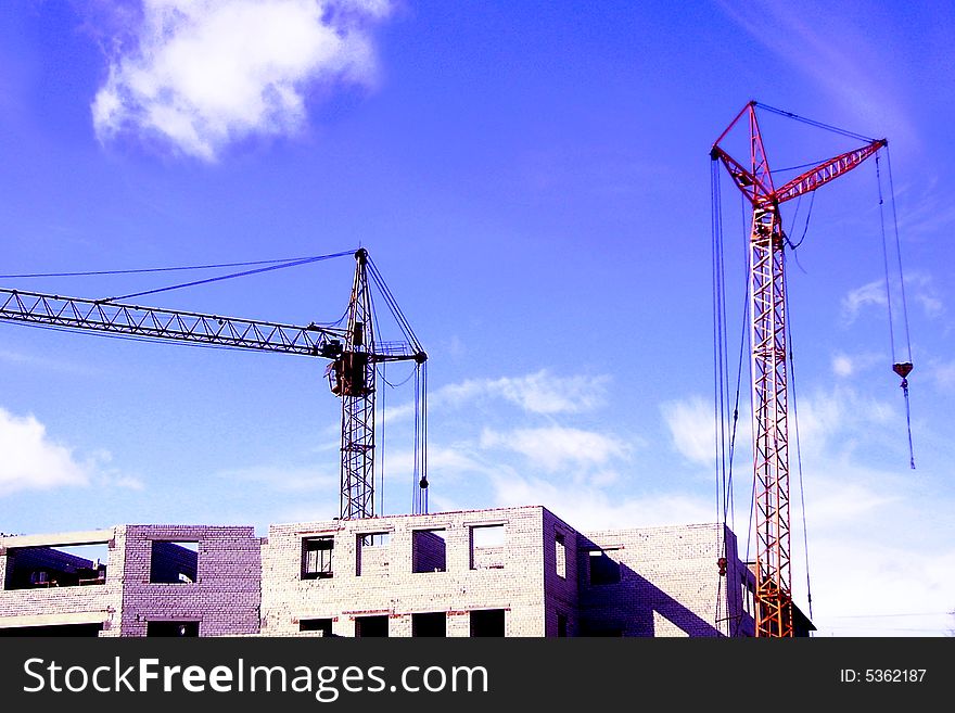 Construction of a new building by the hoisting cranes. Construction of a new building by the hoisting cranes.