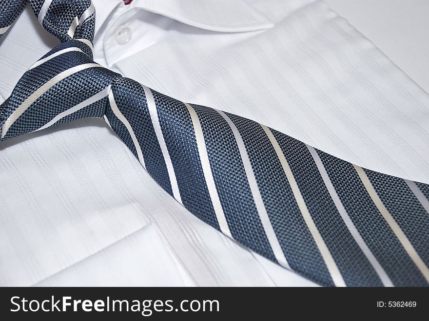 Striped necktie with unit closeup on the white shirt. Striped necktie with unit closeup on the white shirt