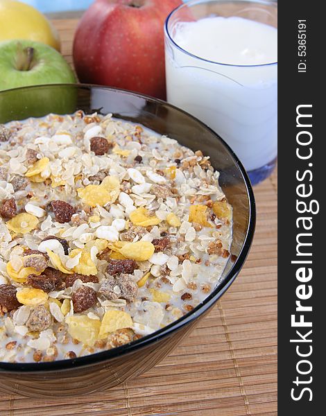 Corn flakes with milk and fruits on a deep plate