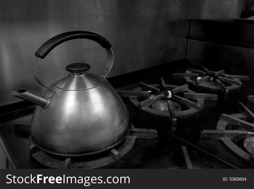 A water kettle on an old iron stove top.