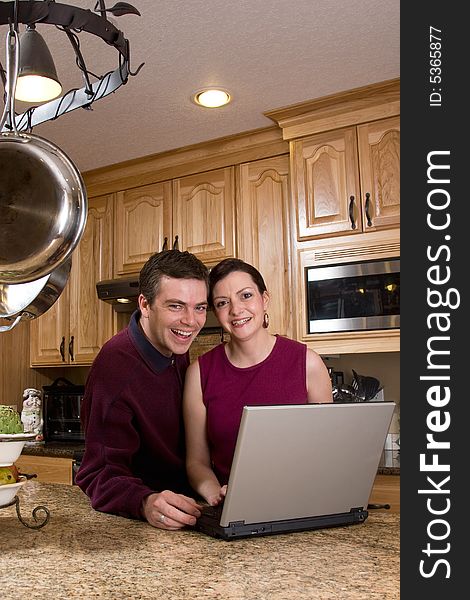 Couple With Laptop In Kitchen - Vertical