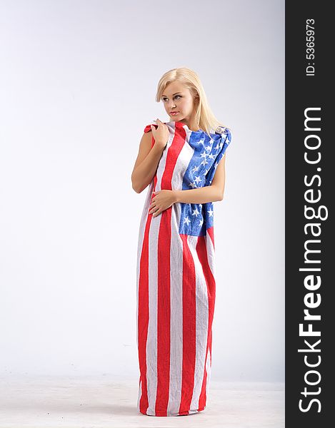 Naked young woman in American flag stand on a white background. Naked young woman in American flag stand on a white background