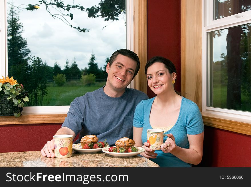 A smiling couple eating continental breakfast at home. A smiling couple eating continental breakfast at home.