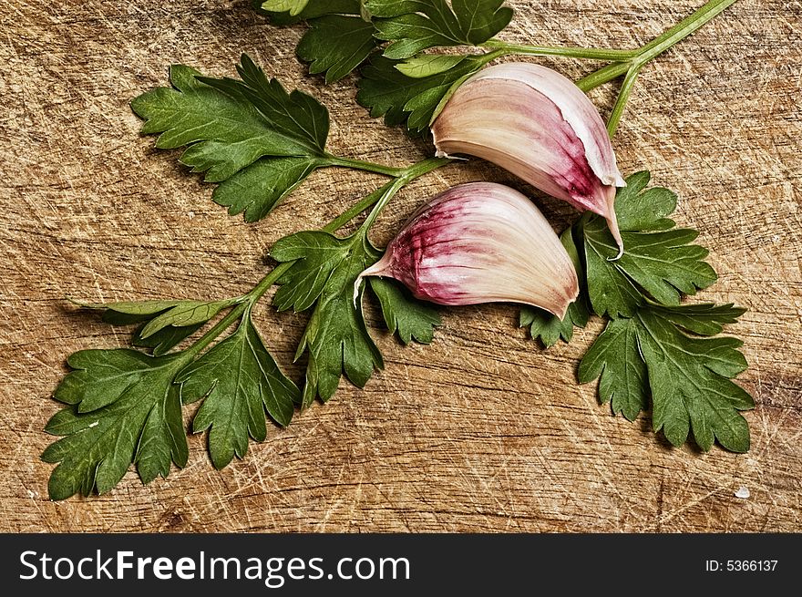 Garlic and parsley isolated on wooden background. Garlic and parsley isolated on wooden background.