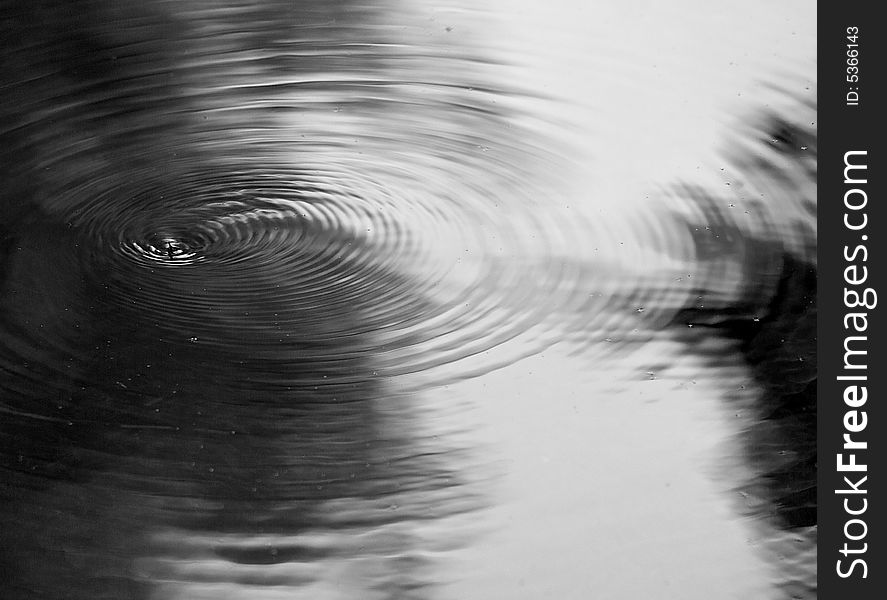 Gnats dancing on the surface of a river, causing ripples and abstract patterns. Gnats dancing on the surface of a river, causing ripples and abstract patterns