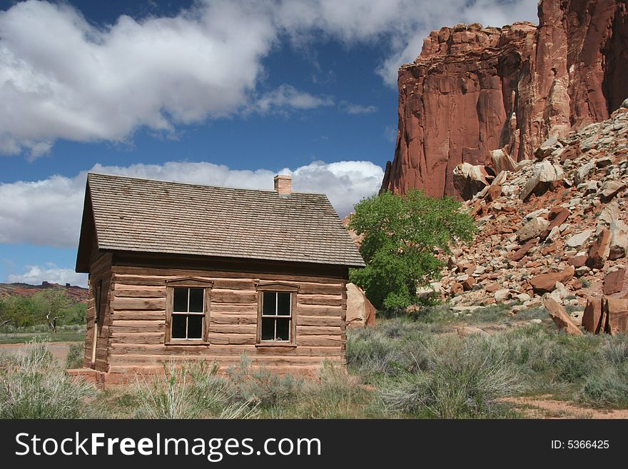 Historic one room log school house in Capitol Reef National Park. Geologic features in background. Utah. USA. Historic one room log school house in Capitol Reef National Park. Geologic features in background. Utah. USA