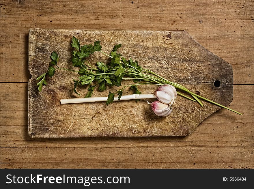 Garlic and parsley isolated on wooden background. Garlic and parsley isolated on wooden background.