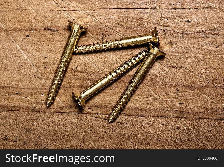 Bronze screws on wooden table, studio shot. Bronze screws on wooden table, studio shot.