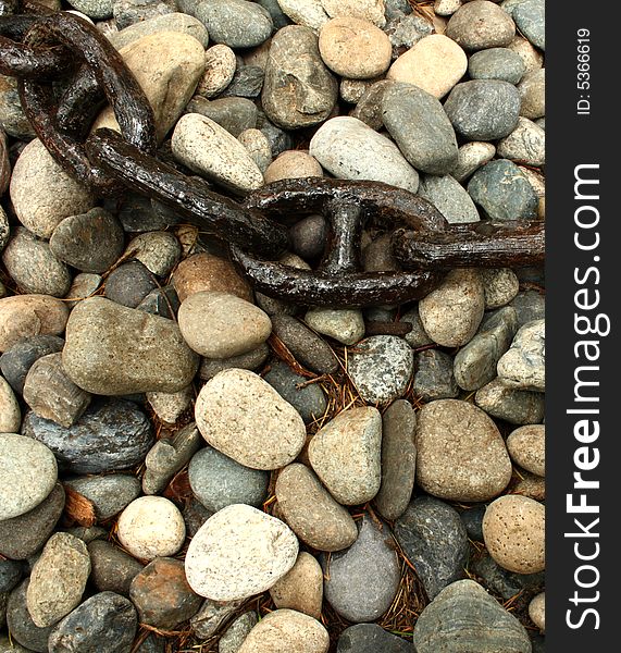 Close up on an old and rusty chain over a stone surface