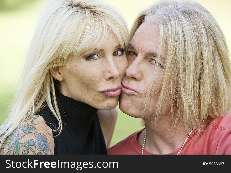 Outdoor portrait of a hip man and woman kissing. Outdoor portrait of a hip man and woman kissing