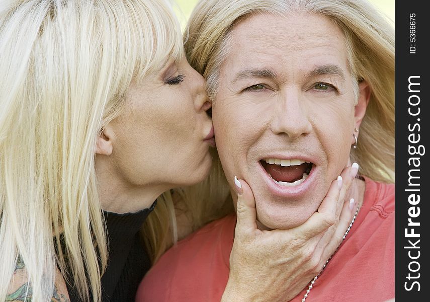 Outdoor portrait of a woman kissing a man