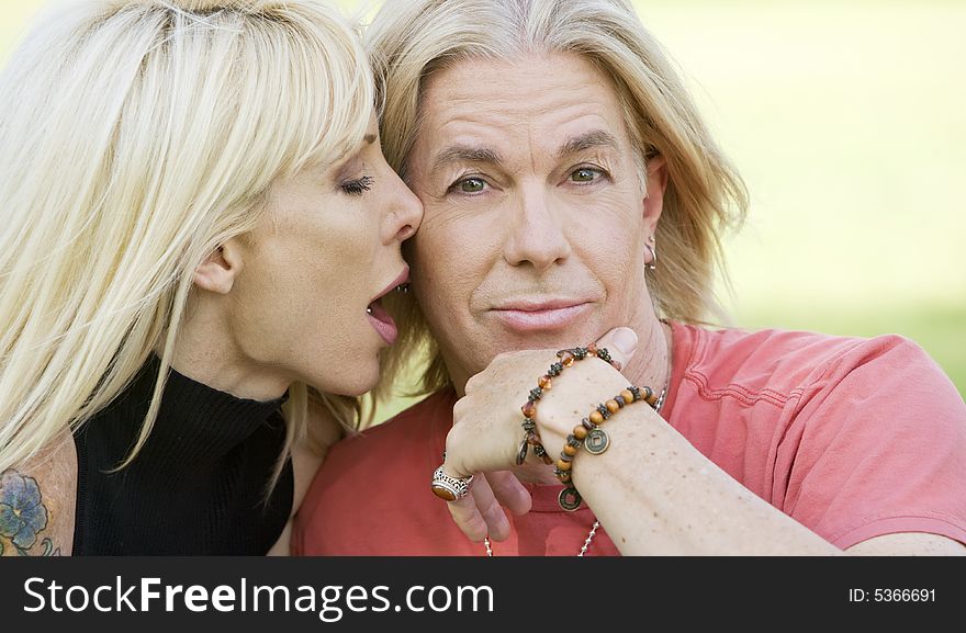 Outdoor portrait of a woman kissing a man