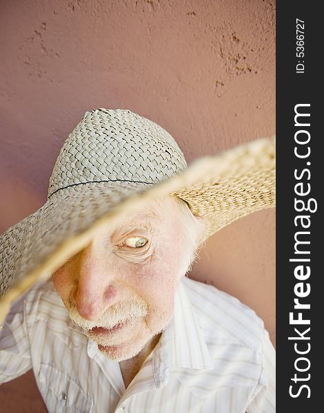 Senior Citizen Man with a Funny Expression Wearing a Straw Cowboy Hat. Senior Citizen Man with a Funny Expression Wearing a Straw Cowboy Hat