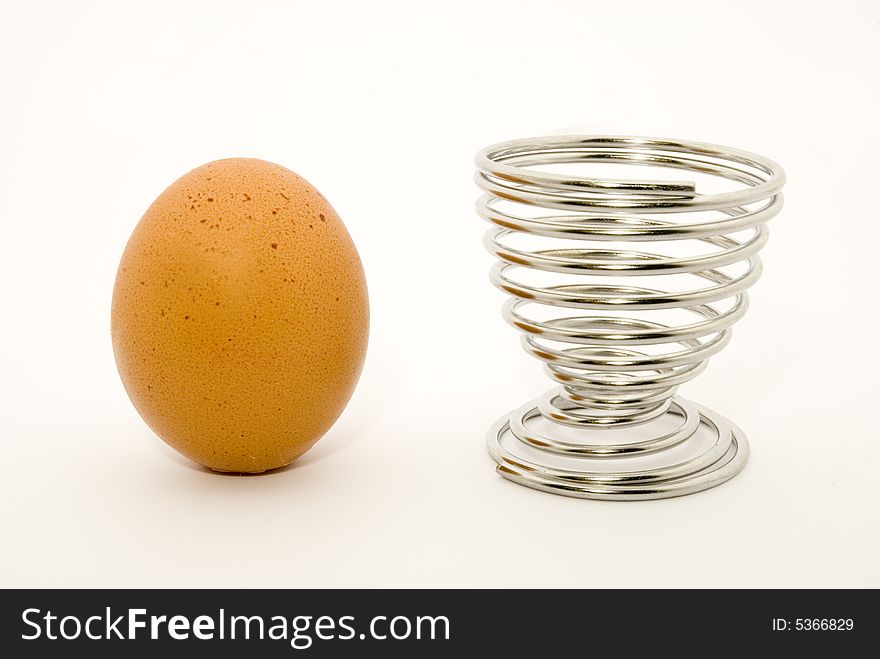Still-life with an egg and an egg cup placed over white background. Still-life with an egg and an egg cup placed over white background
