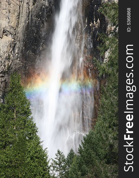 Colorful rainbow over the famous natural landmark Yosemite fall. Yosemite national park. California. USA. Colorful rainbow over the famous natural landmark Yosemite fall. Yosemite national park. California. USA