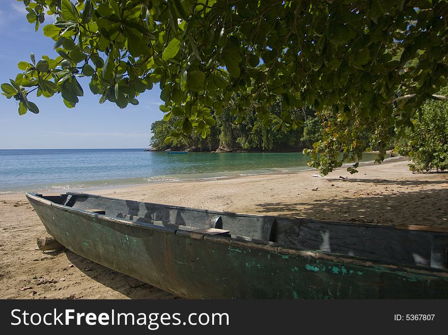 A boat in the shade on a tropical beach. A boat in the shade on a tropical beach