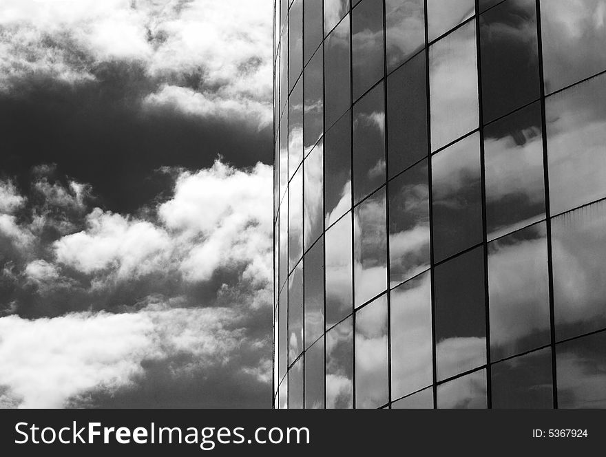 The glass windows of a skyscraper and clouds' reflections in Belize City, Belize. The glass windows of a skyscraper and clouds' reflections in Belize City, Belize.