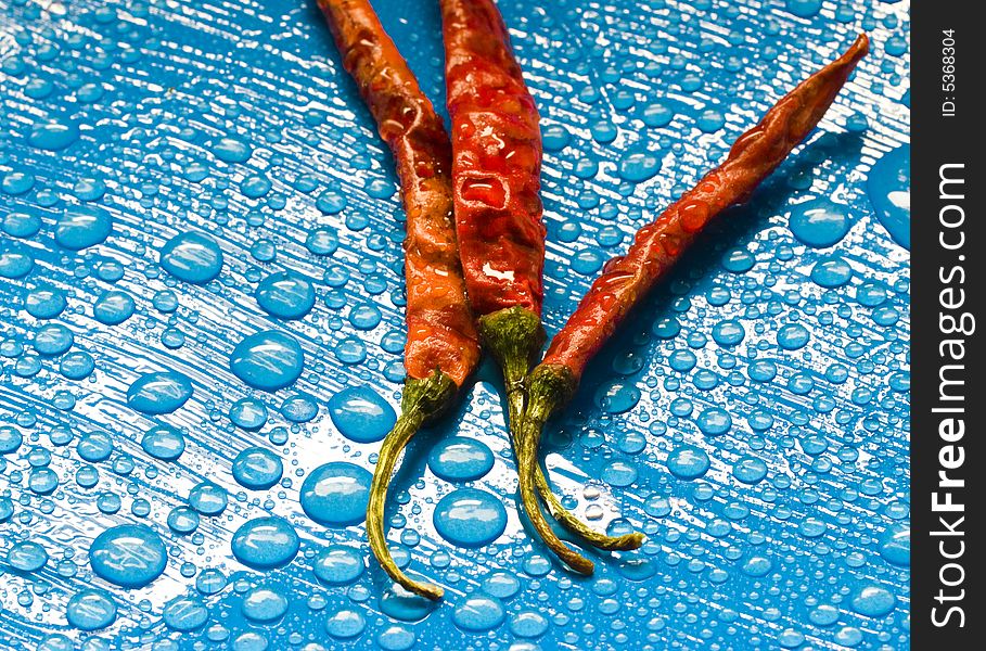 Dried red chili peppers and water drops. Dried red chili peppers and water drops.