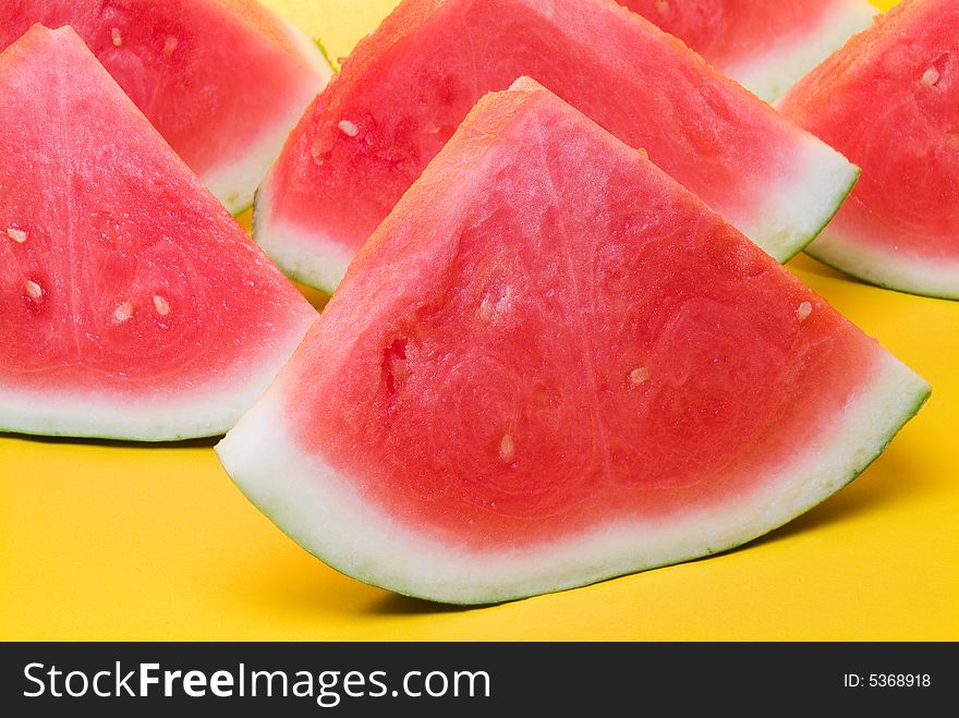 Juicy slices of watermelon in yellow background