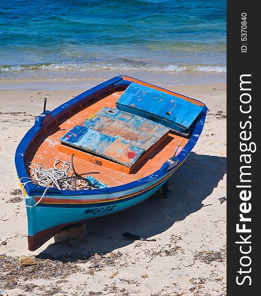 Old boat on the beach painted by orange and blue color. Old boat on the beach painted by orange and blue color