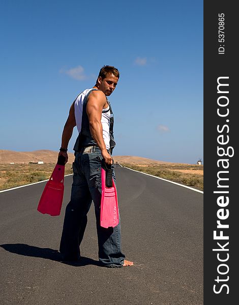 Young athetlic man in the middle of a road. Young athetlic man in the middle of a road