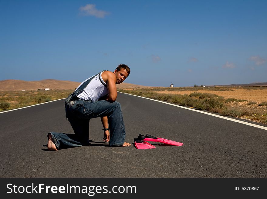 Young athetlic man in the middle of a road. Young athetlic man in the middle of a road