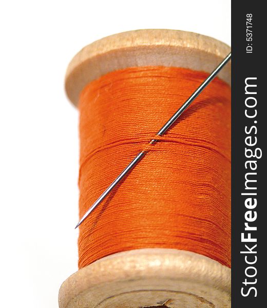 Sewing spool with a needle. A sewing needle.