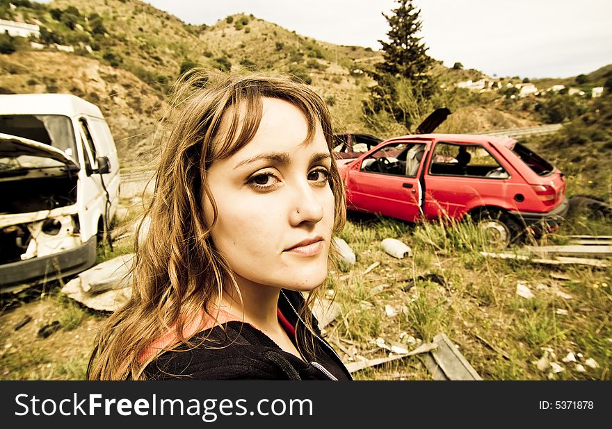 Young woman in the scrapyard, wide angle