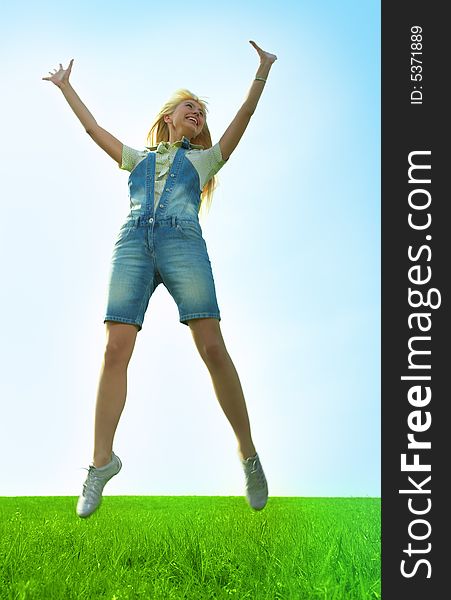 Happy beauty young woman jump in field with green grass