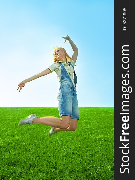 Happy beauty young woman jump in field with green grass