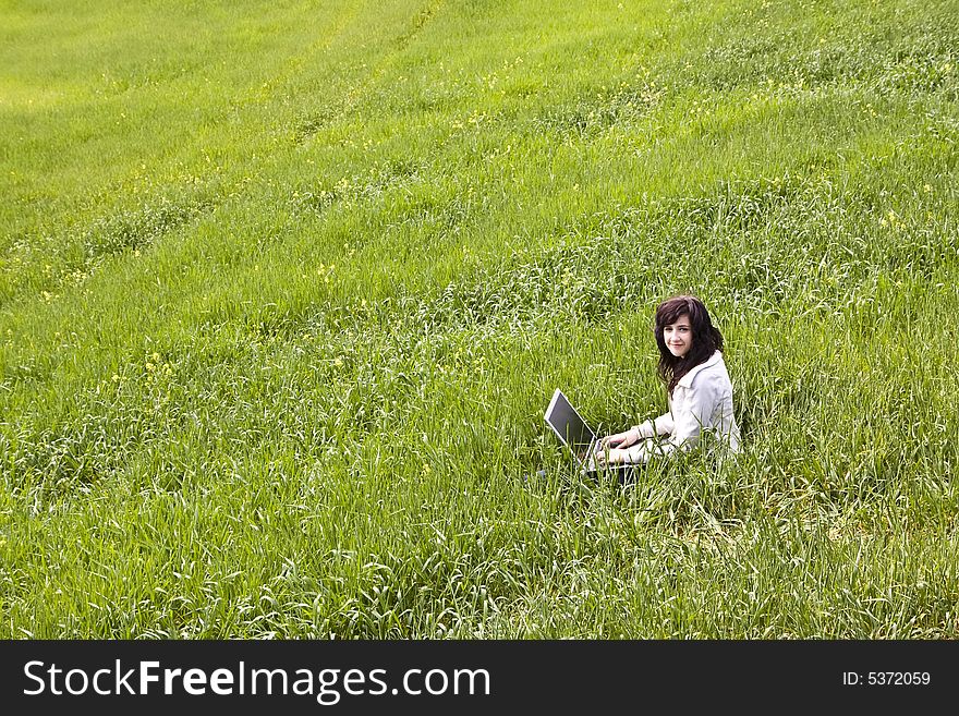 Young woman connected to the internet in a meadow. Young woman connected to the internet in a meadow