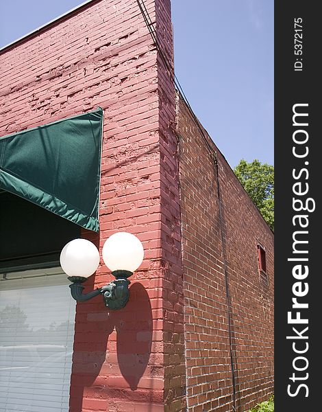 Old fashioned globe lights on a red painted brick building. Old fashioned globe lights on a red painted brick building