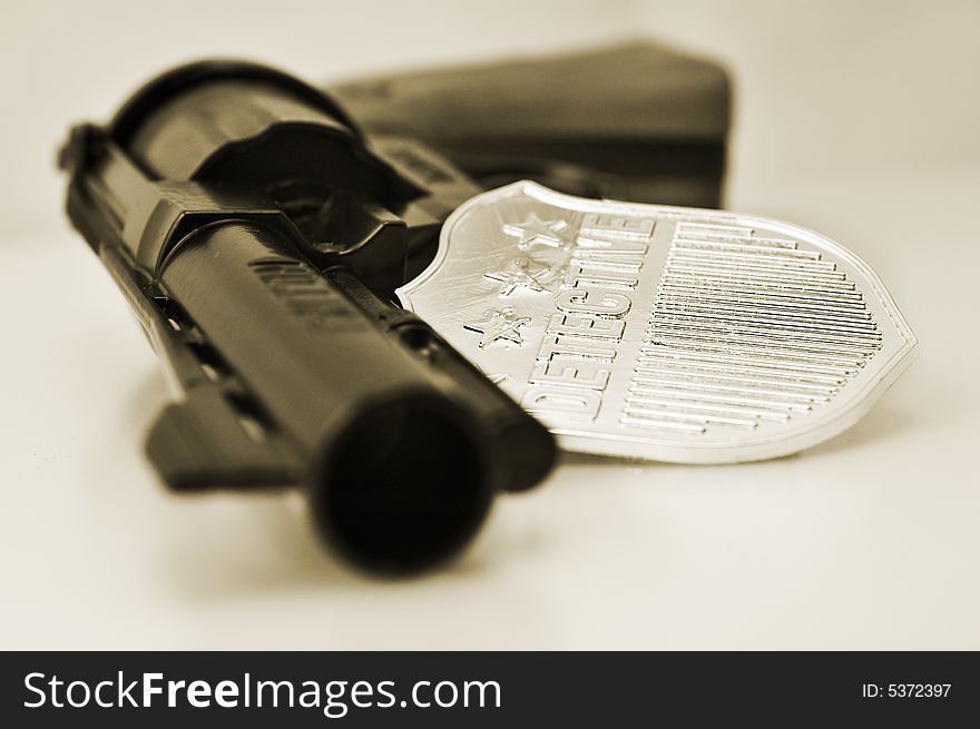Detective badge and revolver with very shallow depth of field