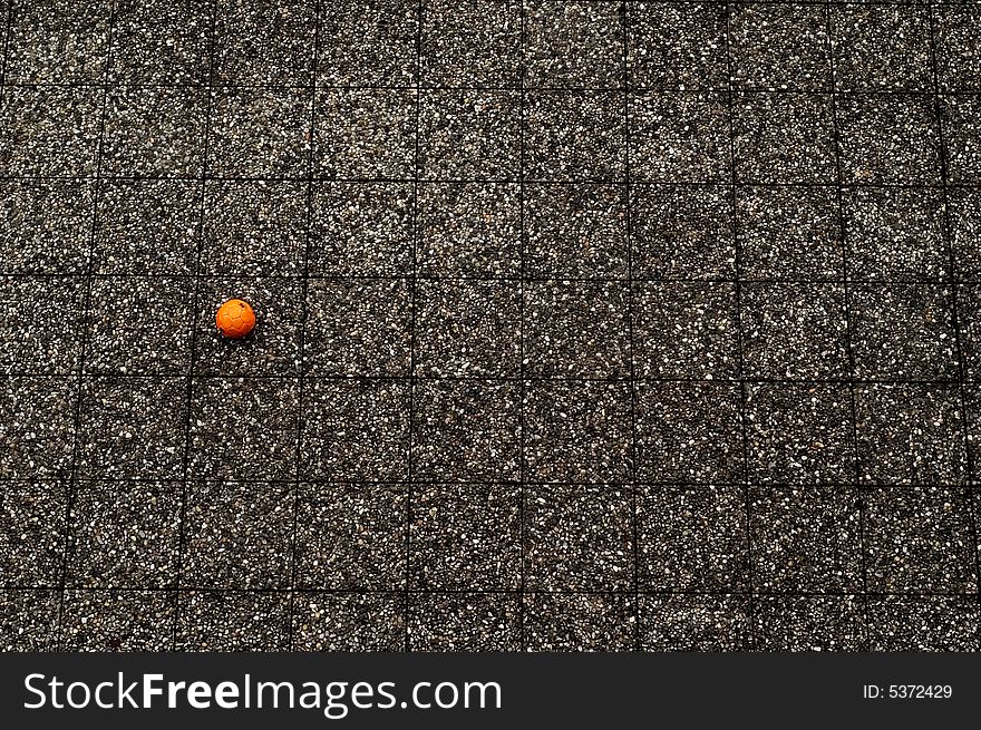 Abandoned orange soccer ball in yard