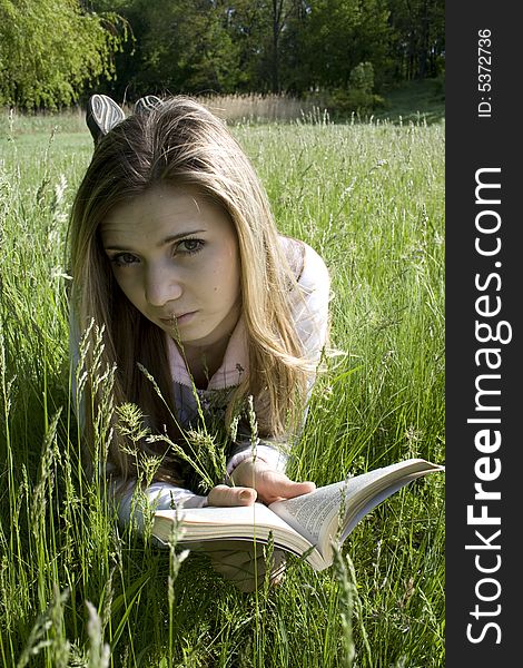 Girl with book on grass