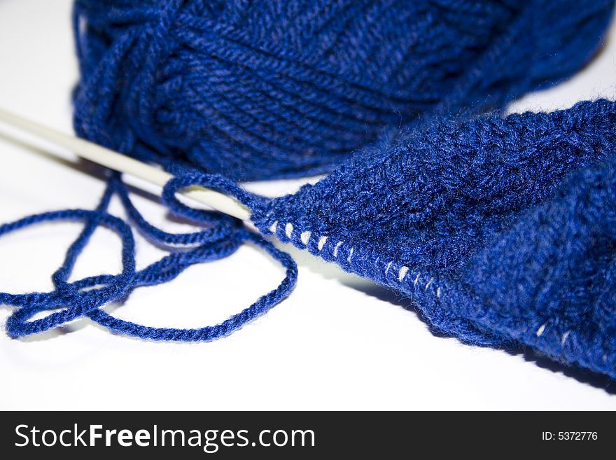 Blue wool with a knitting needle