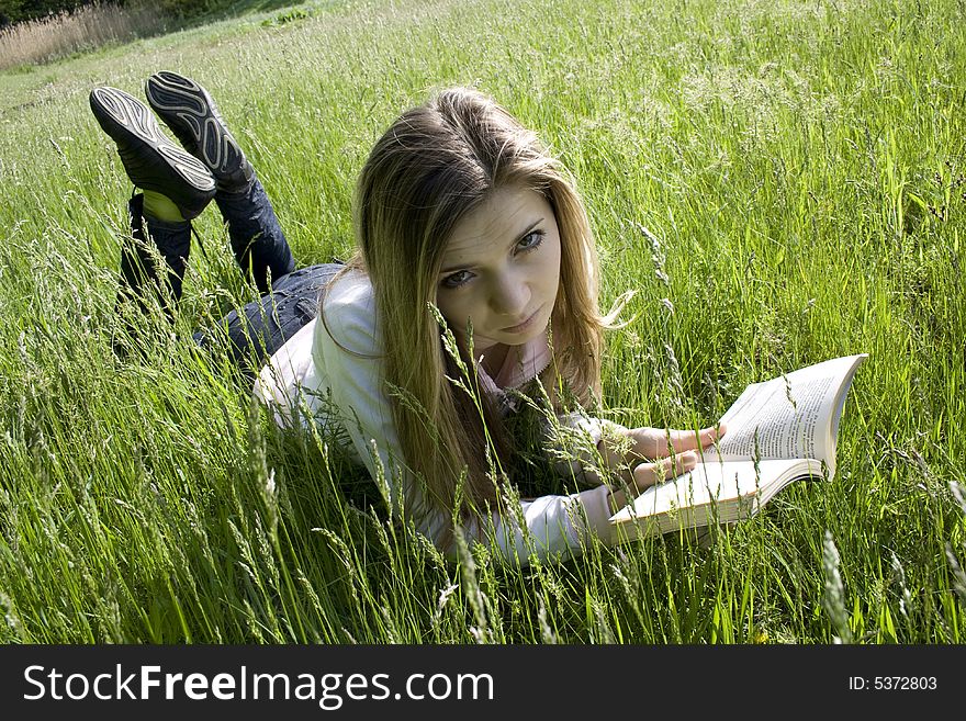 Girl read a book on grass. Girl read a book on grass