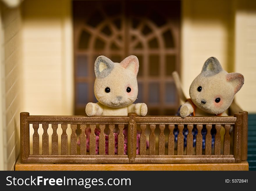 Toy kitties on the balcony of the toy house